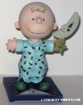 Charlie Brown wearing pajamas and holding moon Figurine