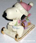 Snoopy and Woodstock sitting on sled with presents