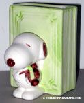 Snoopy standing next to green book playing violin Planter