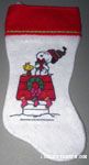 Snoopy hugging gift on doghouse with Woodstock Stocking