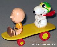 Charlie Brown & the Flying Ace sitting on yellow curved skateboard