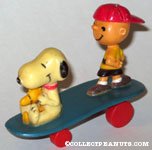 Snoopy & Woodstock sitting and Charlie Brown Standing on blue curved skateboard