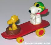 Flying Ace and Woodstock in Nest on red curved skateboard