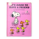 Cover of It's Good to Have a Friend Peanuts Pop-Up Book by Charles M. Schulz against a bright pink background, featuring Snoopy doing a happy dance next to a group of yellow and orange Woodstock birds interacting at the bottom, with the title text "It's Good to Have a Friend" at the top.