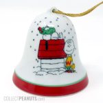 Snoopy on doghouse with wreath on his nose, Charlie Brown and Woodstock standing Christmas Bell Ornament