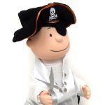 A Charlie Brown animated pirate doll wearing a black tricorn hat with a skull and crossbones emblem, an eye patch, a white ruffled shirt, and a vest while holding a toy plastic dagger.