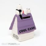 Joe Cool laying on Purple Doghouse 'Cool Cash' Bank