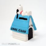 Joe Cool laying on Blue Doghouse 'Cool Cash' Bank