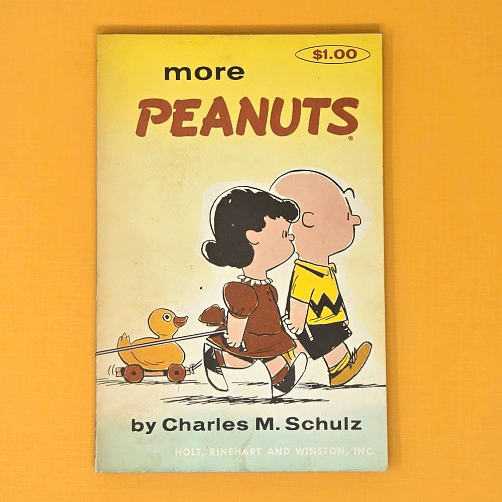 Cover of the Peanuts book "More Peanuts" by Charles M. Schulz featuring Lucy kissing Charlie Brown on the cheek.