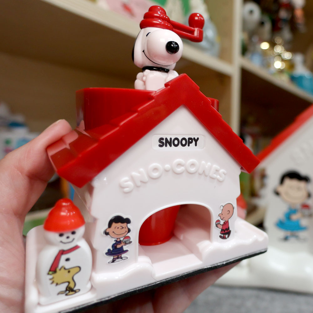 Miniature collectible World's Smallest Snoopy Sno-Cone Machine toy displaying Snoopy on top of a red and white doghouse shaped ice shaver.
