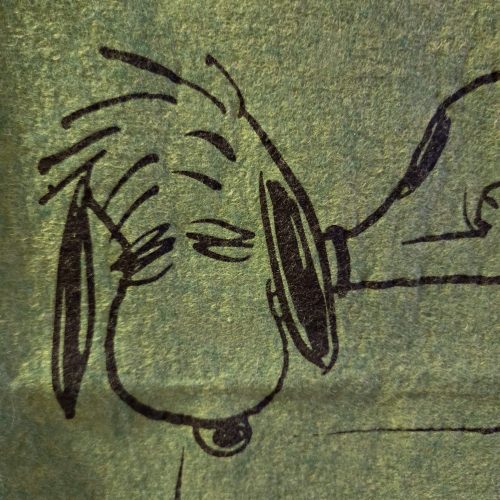 A close-up illustration printed on textured green felt, showing a sleepy Snoopy with his eyes closed and messy hair sticking up.