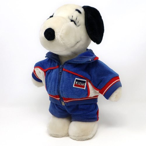 A vintage Levi's Belle 1984 Olympics Standing Plush Doll wearing a blue, white, and red athletic warmup jacket and matching pants with red ribbed cuffs.